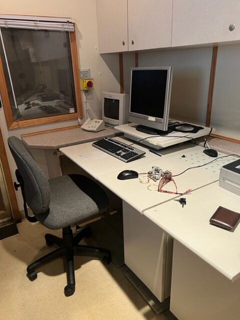 A computer desk with a chair and monitor