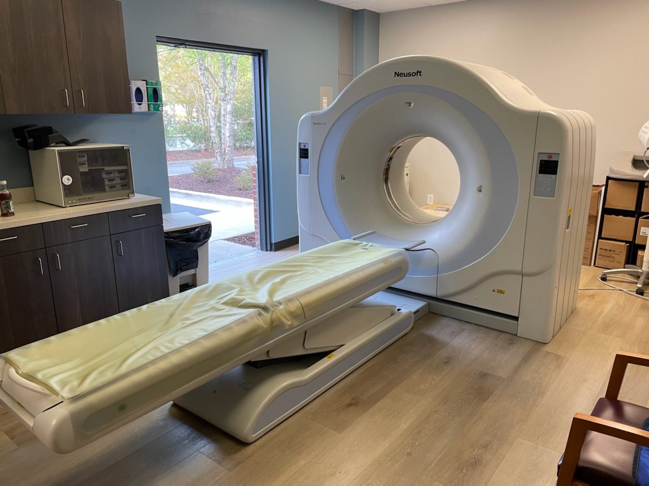 A white mri machine in a room with wood floors.